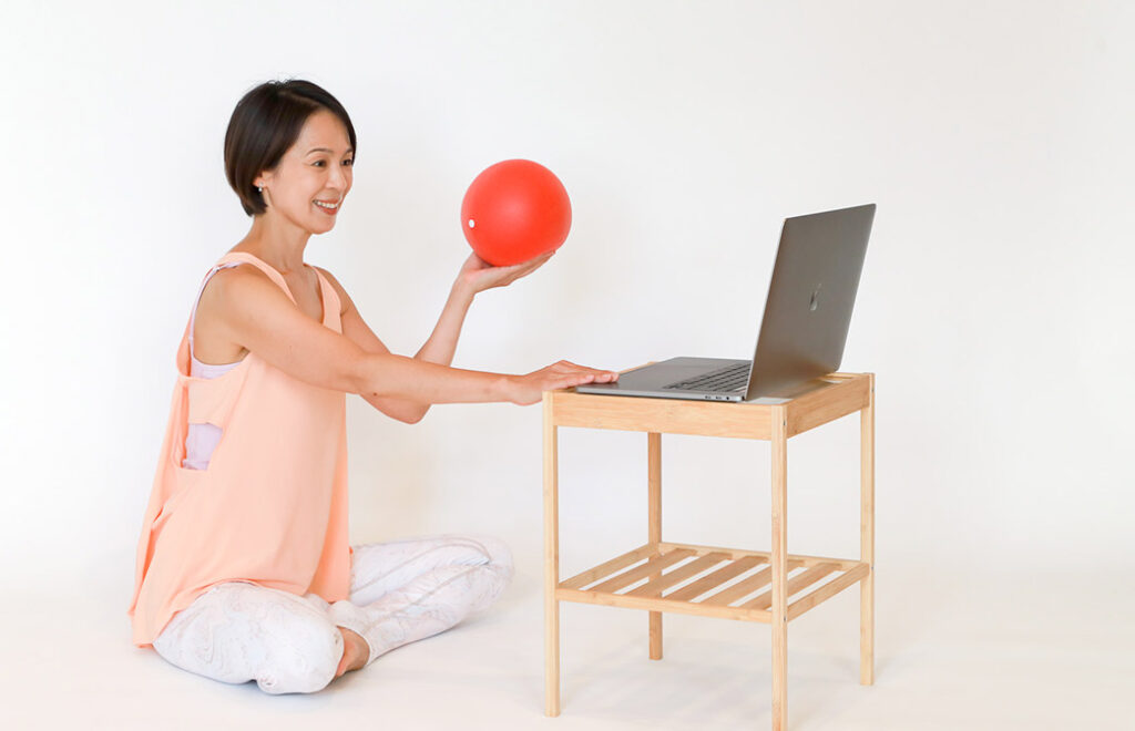 Miwa先生がピラティスボールを持ってパソコン前で講義をしている